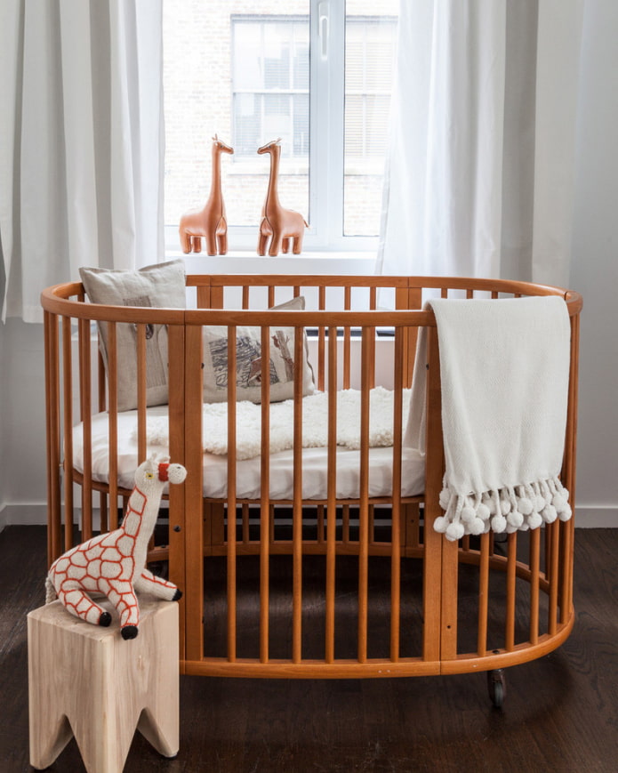 овальная кроватка для малыша в интерьере