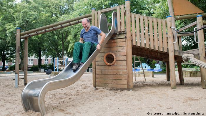 Man testing slide at the playground (picture-alliance/dpa/J. Stratenschulte)